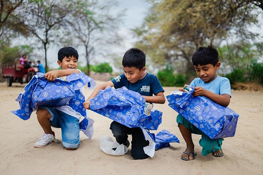 Niños abriendo regalos de navidad en Compassion